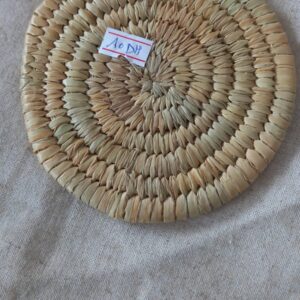 un dessous-de-plat en paille tressée (ou osier/rotin).